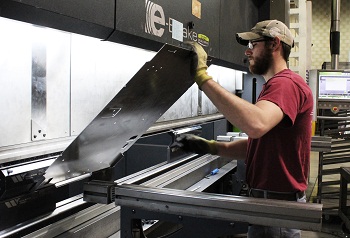 Operator bending a metal part in the Safan brake press for a sheet metal fabrication job