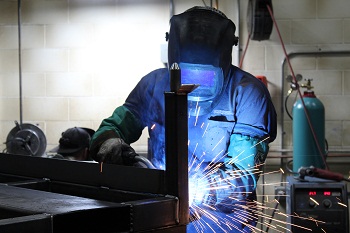 Certified MIG Welder works on a custom weldment for a contract assembly job